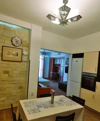 a kitchen and dining room with a table and a chandelier at Оазис 1 във Варна in Varna City