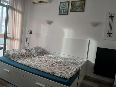 a bed sitting in a room with a window at Оазис 2 във Варна in Varna City