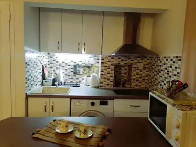 a kitchen with a sink and a stove top oven at Оазис 2 във Варна in Varna City