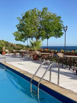 a swimming pool with tables and chairs and the ocean at Dolce Vita Blue Boho, Premium Apartment with seaview in Sveti Vlas