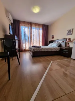 a bedroom with a bed and a wooden floor at Deluxe Admiral Plaza in Sunny Beach