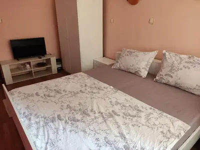 a bedroom with a bed and a tv on a table at Стая за гости на град Бургас. in Burgas City