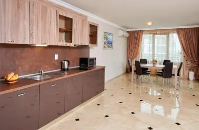 a kitchen with a sink and a table with chairs at Boutique Rose Gardens Pomorie in Pomorie