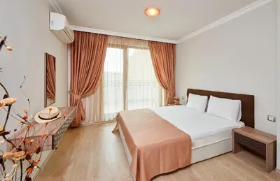 a bedroom with a bed and a large window at Boutique Rose Gardens Pomorie in Pomorie