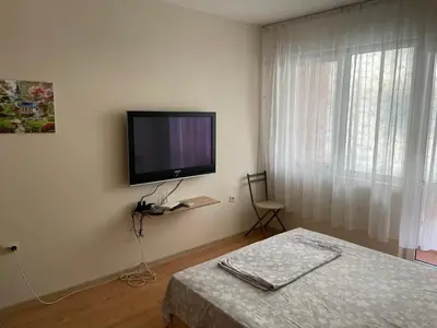 a bedroom with a flat screen tv on the wall at Апартамент Александр 1 in Burgas City
