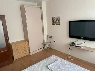 a bedroom with a flat screen tv on the wall at Апартамент Александр 1 in Burgas City