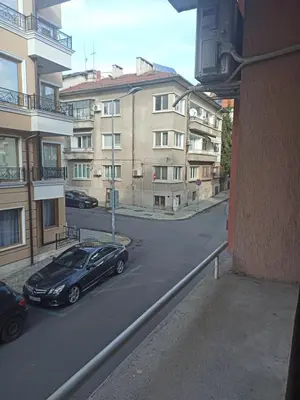 a black car parked in a parking lot next to buildings at Апартамент Александр 1 in Burgas City