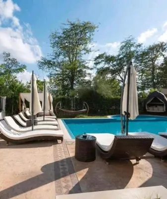 a swimming pool with lounge chairs and umbrellas at Deluxe Apartments Приморско in Primorsko