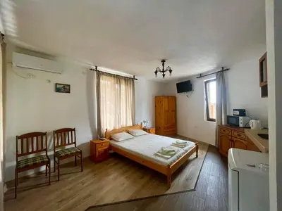 a bedroom with a bed and two chairs in it at Sozopol Old Town - Studio 1 in Sozopol
