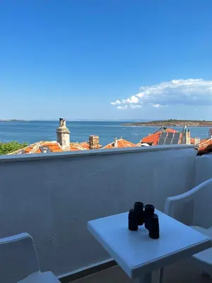a table with two mugs on top of a balcony at Sozopol Old Town - Studio 5 Attic in Sozopol