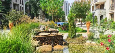 a garden with rocks and plants and buildings at Attractive Family Apartment in Sunny Beach Cascadas Family Resort in Sunny Beach