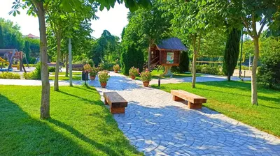 a park with benches and a cabin in the background at Attractive Family Apartment in Sunny Beach Cascadas Family Resort in Sunny Beach