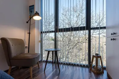 a room with a chair and a large window at Студио в близост до Община Варна in Varna City