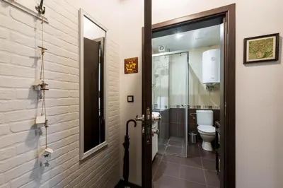 a bathroom with a toilet and a glass door at Студио в близост до Община Варна in Varna City