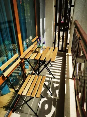 a picnic table on a balcony with a potted plant at Студио Sun day в Royal palm, Свети Влас in Sveti Vlas