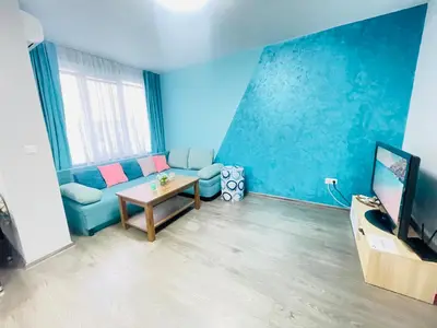 a blue living room with a couch and a table at By The Sea - central with free parking in Varna City