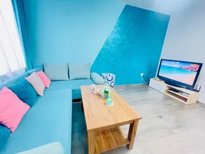 a living room with a blue couch and a coffee table at By The Sea - central with free parking in Varna City
