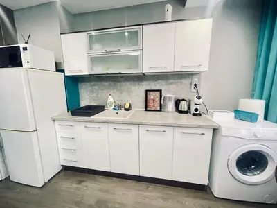 a white kitchen with a sink and a washing machine at By The Sea - central with free parking in Varna City