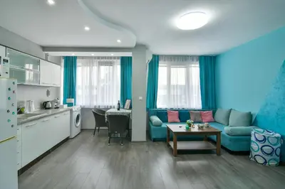 a living room with a blue couch and a table at By The Sea - central with free parking in Varna City