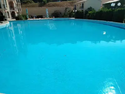 a large pool of blue water in front of a building at Курортен коплекс Елените,община Несебър,област Бургас in Emona