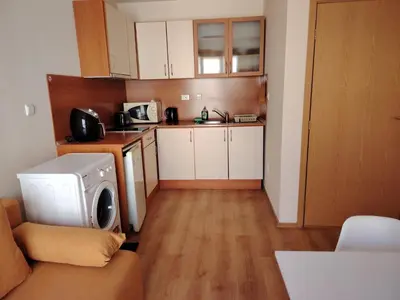 a small kitchen with a washing machine in a room at Ваканционно студио Аквария in Sunny Beach