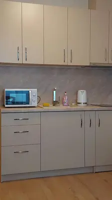 a kitchen with white cabinets and a microwave on a counter at Aphrodite Park in Sunny Beach