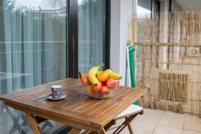 a bowl of fruit on a wooden table with a cup at Апартамент Царски бриз in Sozopol