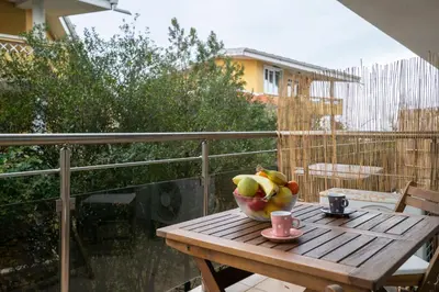 a bowl of fruit on a wooden table on a balcony at Апартамент Царски бриз in Sozopol