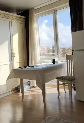 a large white table in a room with windows at Afrodita Palas , studio appartment 4 floor, pool view in Sunny Beach
