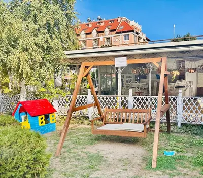 a swing in a yard with a house in the background at Charming 2-bed flat with pool view in Sunny Beach, Bulgaria in Sunny Beach