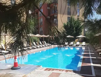 a large blue swimming pool with chairs and umbrellas at Sunny beach apartaments in Sunny Beach