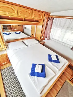 two beds in a small room with blue towels at каравани Дрийм Арапя in Tsarevo