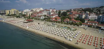 a beach with a lot of umbrellas and a city at VECHNA R 18 Studio Sunny Beach in Sunny Beach