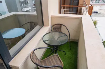 a balcony with two chairs and a table and a window at Sea View Apartment with Free Parking in Pomorie