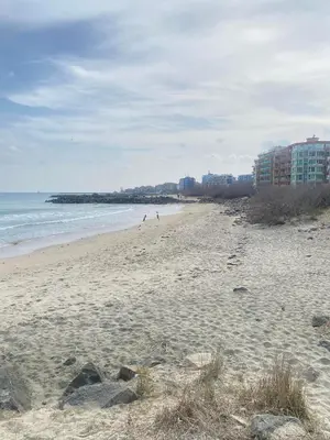 a beach with people walking on the sand and the ocean at Sea View Apartment with Free Parking in Pomorie