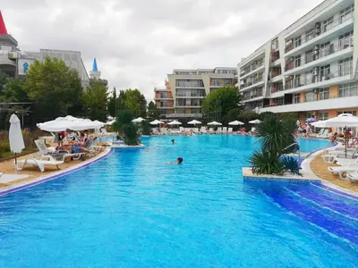 a large swimming pool with people in a resort at Apartment Daisy Grand Kamelia in Sunny Beach