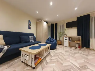 a living room with a blue couch and a table at Sunset Dreams apartment in Burgas City