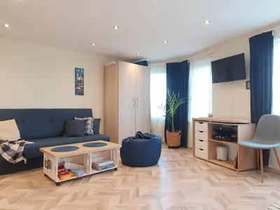 a living room with a blue couch and a table at Sunset Dreams apartment in Burgas City