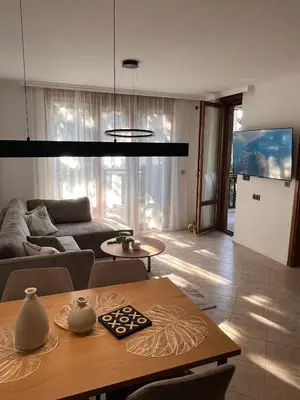 a living room with a table and a couch at Eve Santa Marina Apartments II - sea, pools, relax in Sozopol