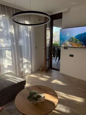 a living room with a table and a tv at Eve Santa Marina Apartments II - sea, pools, relax in Sozopol