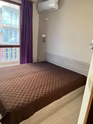 a bedroom with a brown bed with a window at Частен апартамент Стамополу - Private Two-Bedroom Apartment Stamopolu in Primorsko
