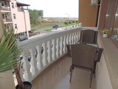 a balcony with two chairs and a view of a street at Частен апартамент Стамополу - Private Two-Bedroom Apartment Stamopolu in Primorsko
