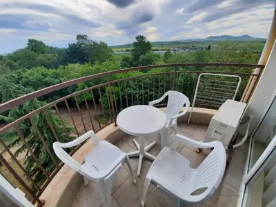 a white table and chairs on a balcony with a view at Midia Grand Rezort in Aheloy