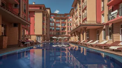 a hotel swimming pool with lounge chairs and buildings at Todorka Sunny View Central w Słonecznym Brzegu in Sunny Beach