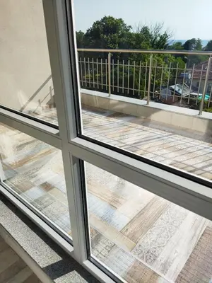 a view of a balcony from a window at Сити бийч вю in Tsarevo