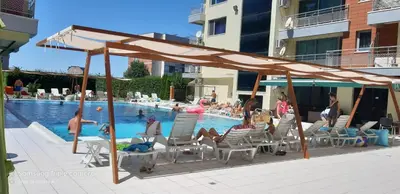 a group of people sitting in chairs by a swimming pool at Apartment Ground Floor in Pomorie