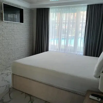 a bed in a bedroom with a large window at Apartment Ground Floor in Pomorie
