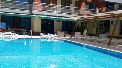 a large swimming pool with chairs and a hotel at Apartment Ground Floor in Pomorie