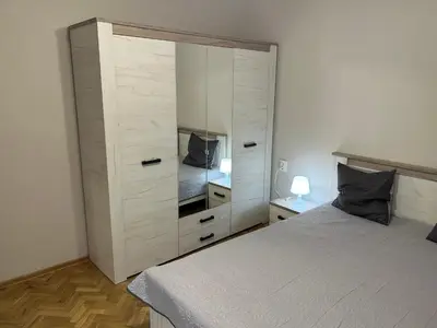 a bedroom with a large white cabinet next to a bed at Niya Apartment Bourgas in Burgas City