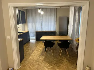 a kitchen with a wooden table and two chairs at Niya Apartment Bourgas in Burgas City